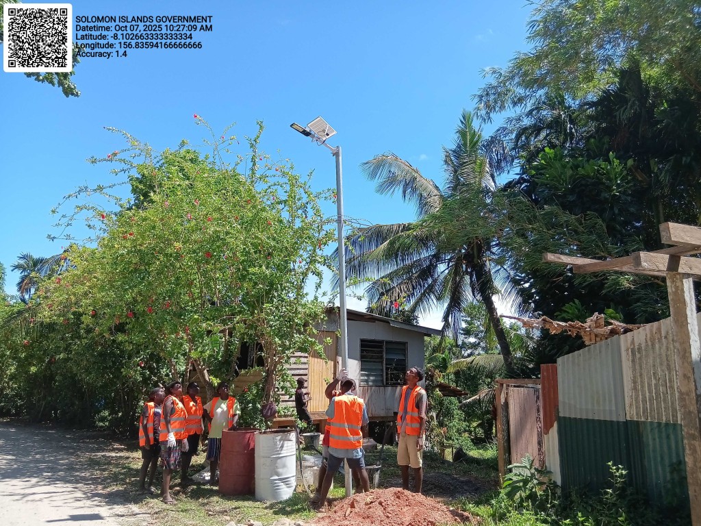 Workers preparing to install another solar light at District